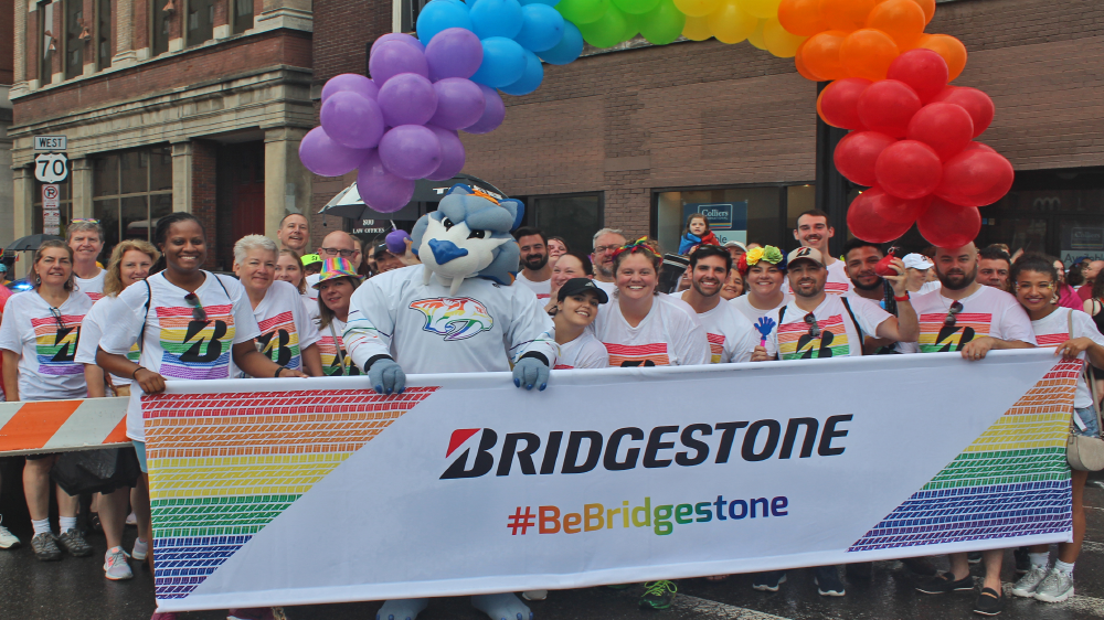 Bridgestone employees and nashville predators mascot gnash walking in 2019 Nashville pride parade