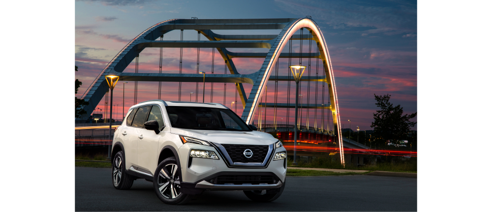 white Nissan rogue in front of bridge