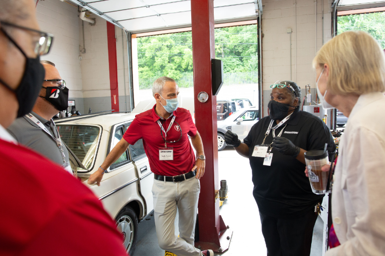 Ms. TJ Williams (center), speaks to former and current officials from Bridgestone Americas about the Auto Training Center at Maplewood High School in Nashville, Tenn.