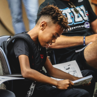 A young student participates in a literacy program in partnership with Bridgestone during the TEU Summit 2023.