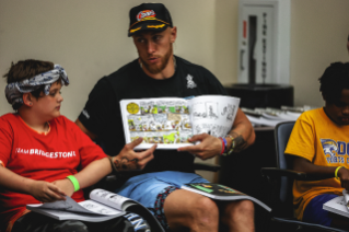 George Kittle reads to kids during a literacy program in partnership with Bridgestone during the TEU Summit 2023.