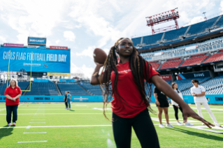 Girls participating in football drills at Titans Field Day