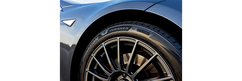 Bridgestone Turanza EV tire shot on passenger side of blue Tesla