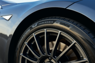 Bridgestone Turanza EV tire shot on passenger side of blue Tesla