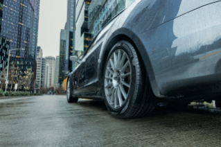 Bridgestone Turanza EV equipped on Tesla in rain with cityscape background