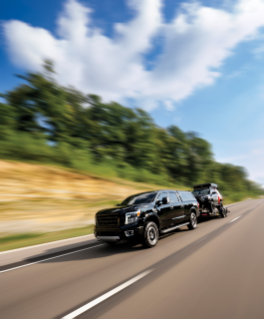 Nissan Titan outfitted with Firestone Airide towing Toyota 4Runner on the highway.